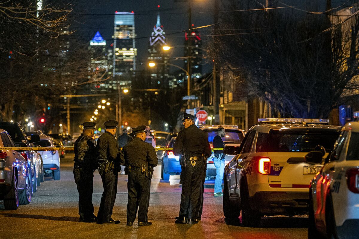Police investigate the scene of a shooting on Tuesday, March 1, 2022 in Philadelphia. An unidentified male teen was fatally shot by police and an officer was injured by shattered glass during a confrontation Tuesday night in South Philadelphia, police said. (Tom Gralish/The Philadelphia Inquirer via AP)