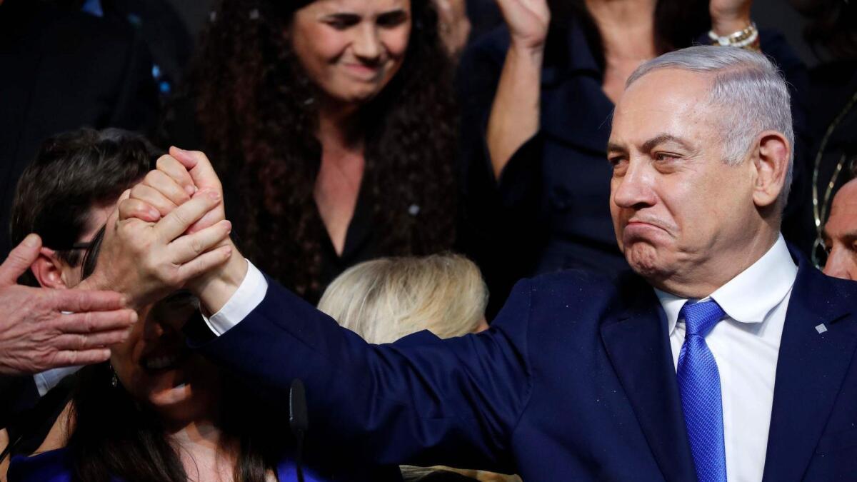 Israeli Prime Minister Benjamin Netanyahu greets supporters at the Likud Party's headquarters in Tel Aviv on election night early on April 10.