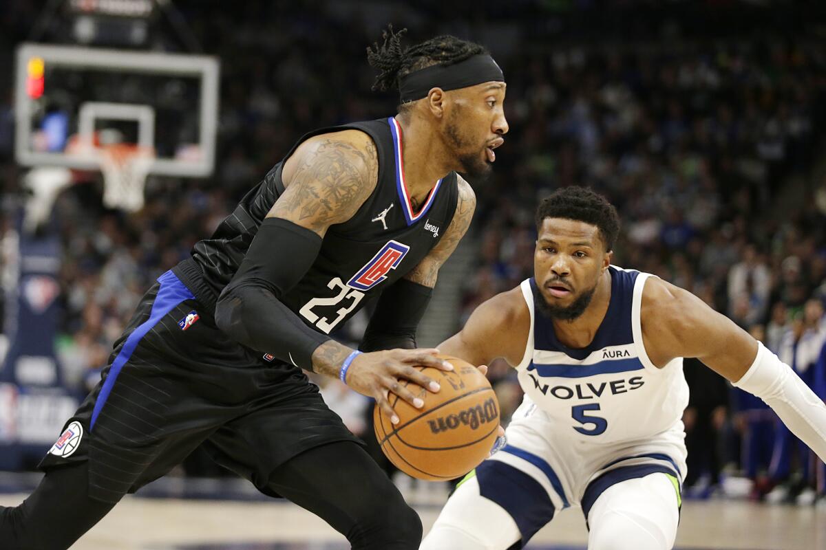 Clippers forward Robert Covington drives on Minnesota Timberwolves guard Malik Beasley on April 12 in Minneapolis.