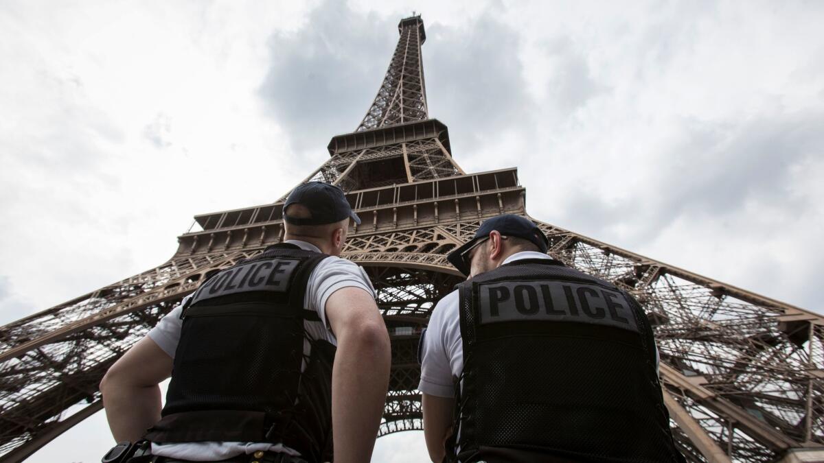 French riot police officers patrol under the Eiffel Tower prior to a Euro 2016 soccer match.