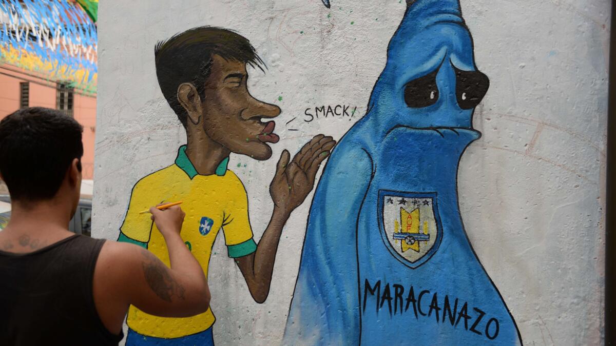Artist Ricardo Mell puts the last touches to a painting in a Rio de Janeiro suburb depicting Brazil's Neymar kissing goodbye to the ghost of the Maracanazo, Brazil's World Cup title loss to Uruguay in 1950.