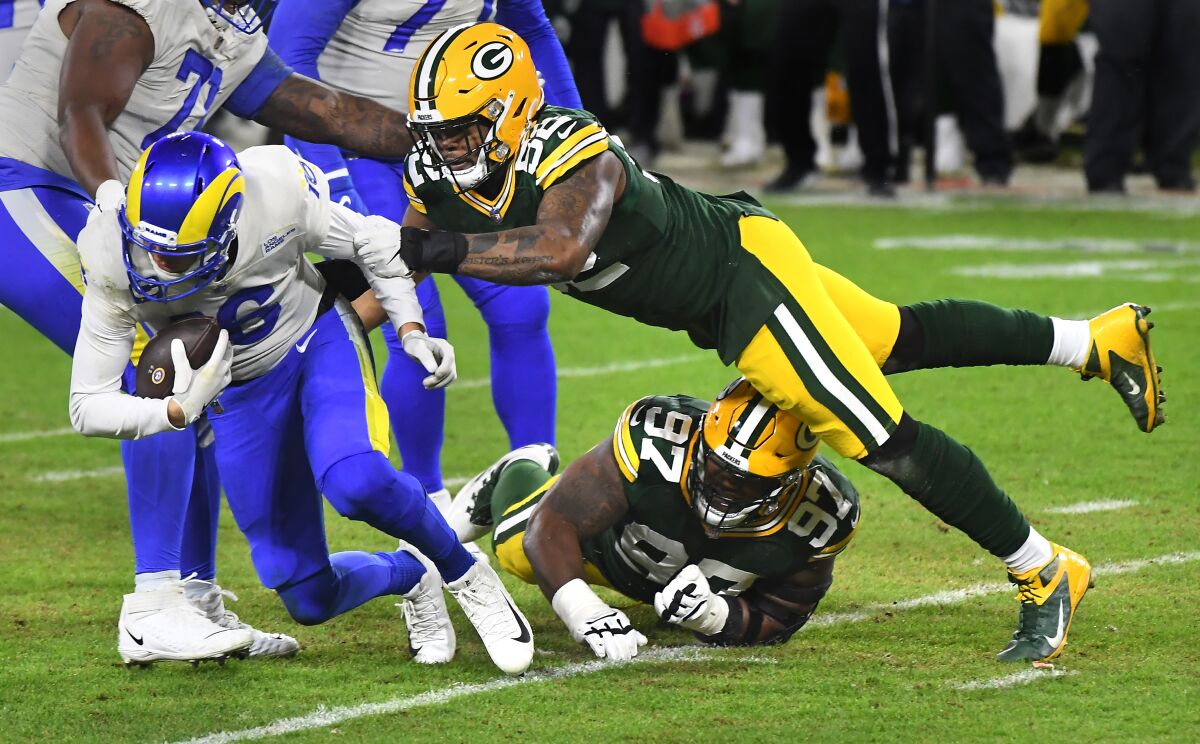 Rams quarterback Jared Goff is sacked by the Packers' Kenny Clark (97) and Rashan Gary (52).