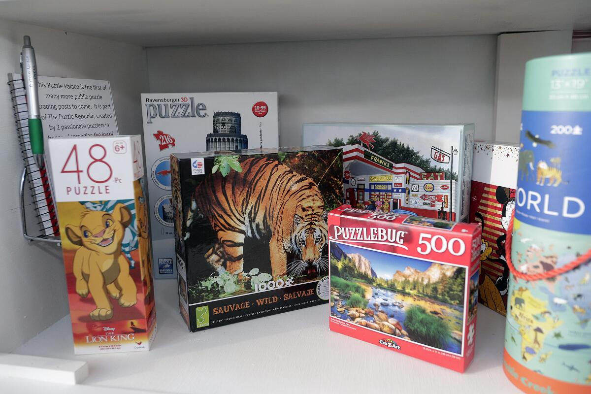 Puzzles in a homemade puzzle trading post, opened on Jan. 26, were placed there by owners Luke and Jessica Cheney and also by neighbors who've left their own donations.