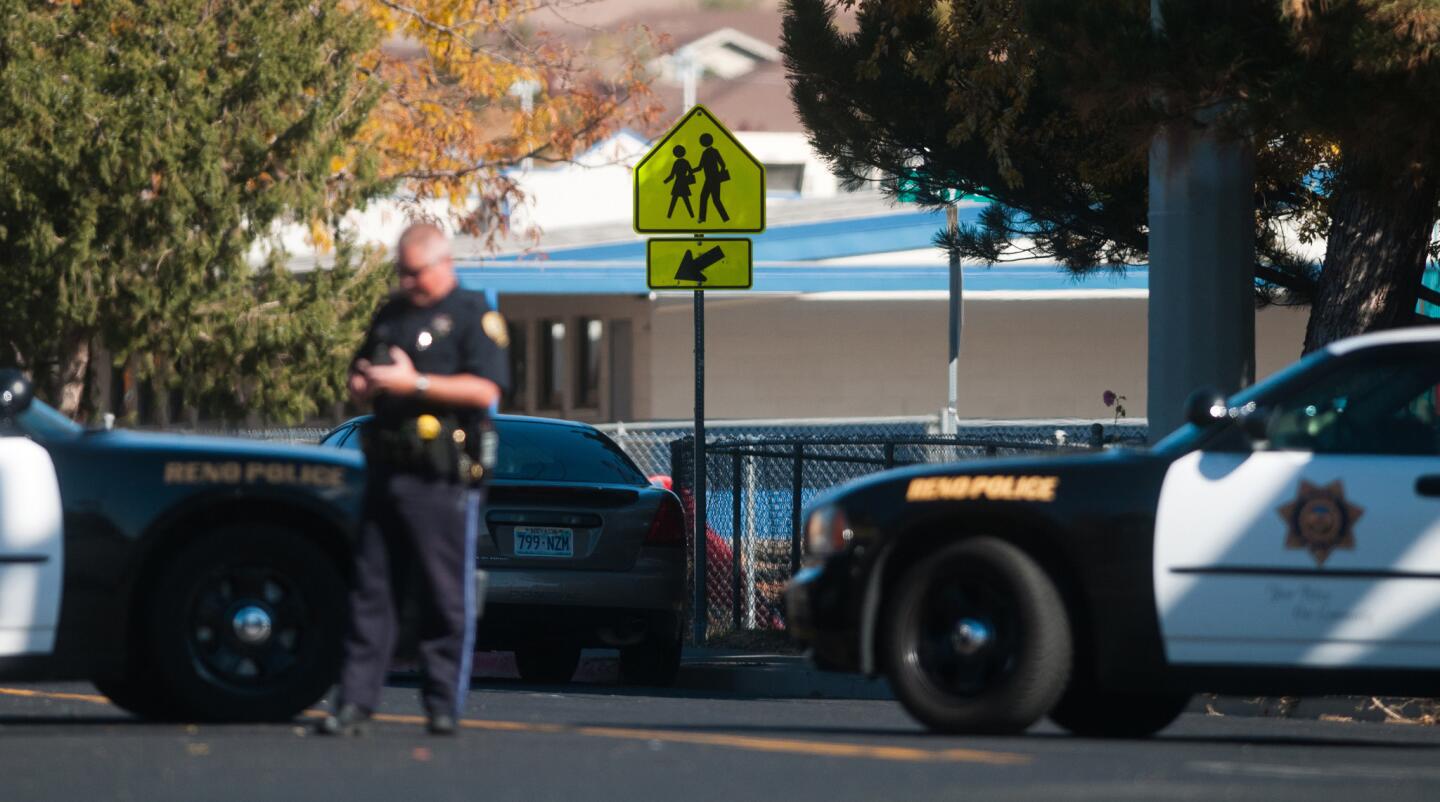 A police officer stops traffic near Agnes Risley Elementary School following a shooting at nearby Sparks Middle School in Sparks, Nev.