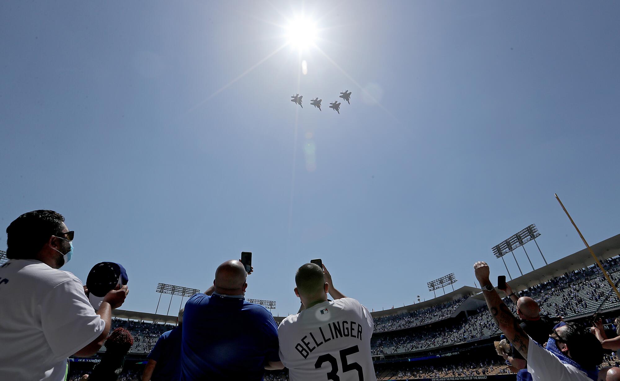 Dodgers fans watch a flyover of military planes before Friday's home opener.