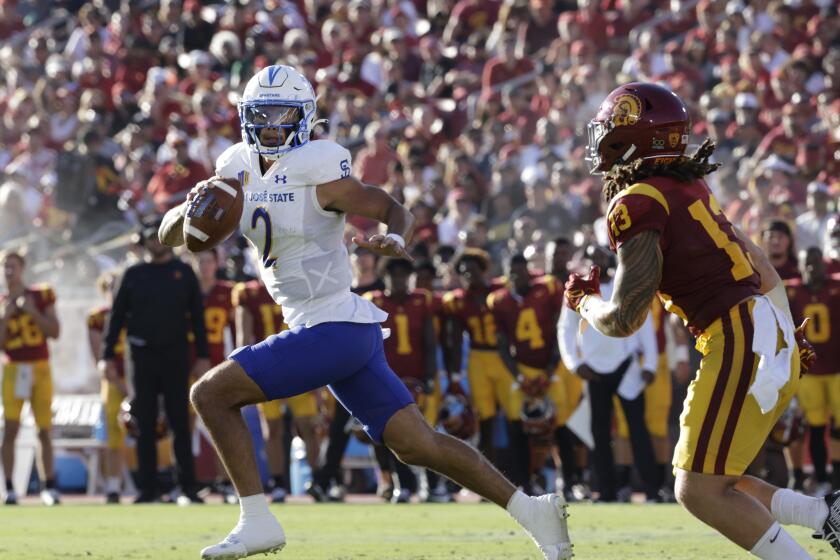 San José State quarterback Chevan Cordeiro is chased by USC linebacker Mason Cobb as he leaves the pocket