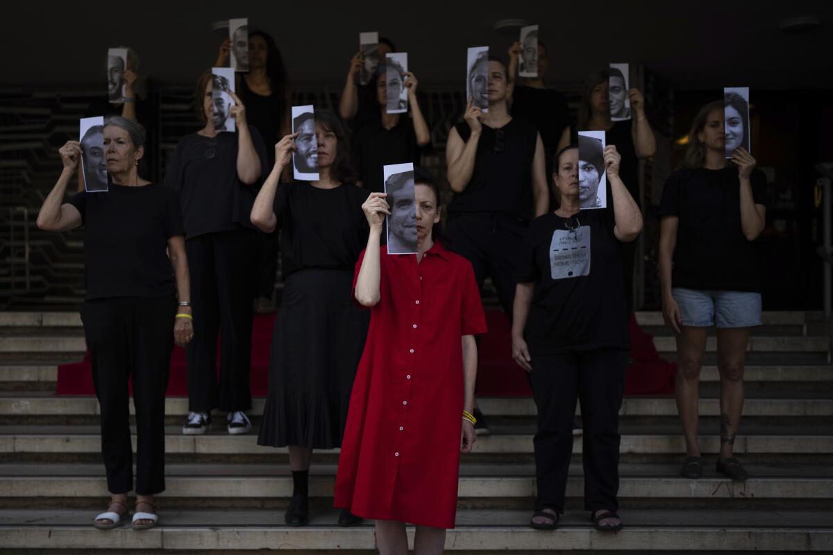 People standing on steps hold half-face images before their own faces