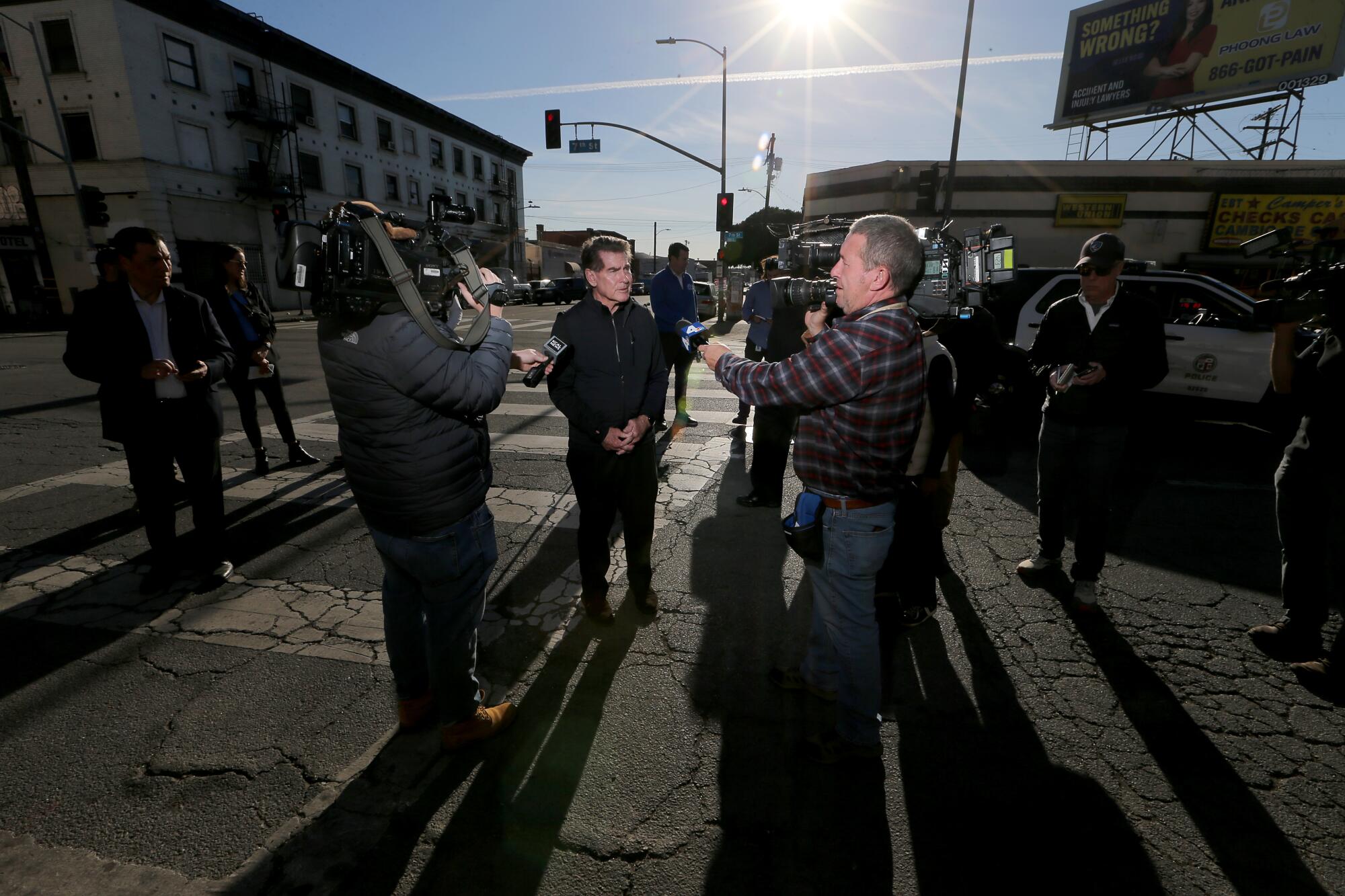 News cameras trail Dodgers great Steve Garvey during his visit to Skid Row in Los Angeles.