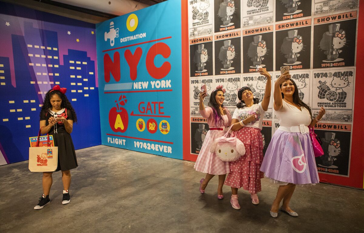 Faheema Chaudhury of Northridge, from left, Jeanne Trejo of Highland Park and Michelle Hernandez of Santa Clarita take selfies inside the New York room at the Hello Kitty Friends Around the World Tour pop-up.