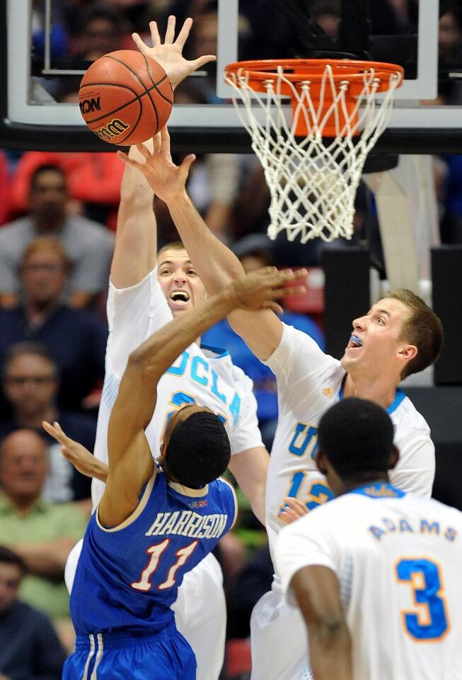 UCLA's David Wear, right, blocks a shot by Tulsa's Shaquille Harrison as Travis Wear goes up to defend during the Bruins' 76-59 win in the second round of the NCAA tournament Friday.