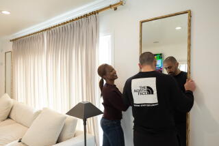 Varooj and Jana Karibyan hang a mirror at their rental house in Glendale.