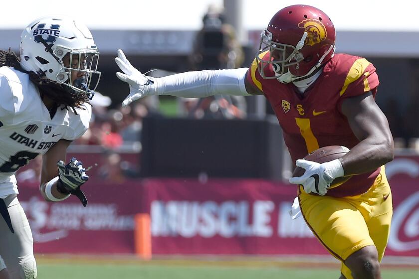 USC receiver Darreus Rogers picks up yards against Utah State defensive back Welsey Bailey during the game Saturday.