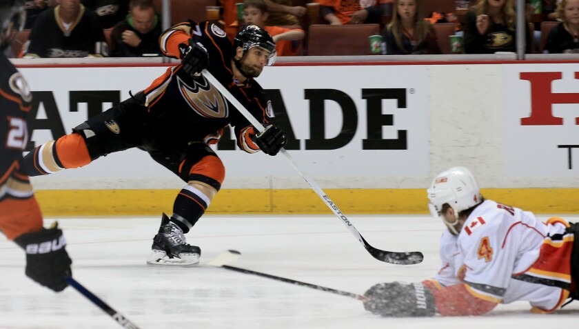 Ducks left wing Andrew Cogliano attempts a shot over Flames defenseman Kris Russell in the first period of Game 2 on Sunday night at the Honda Center.