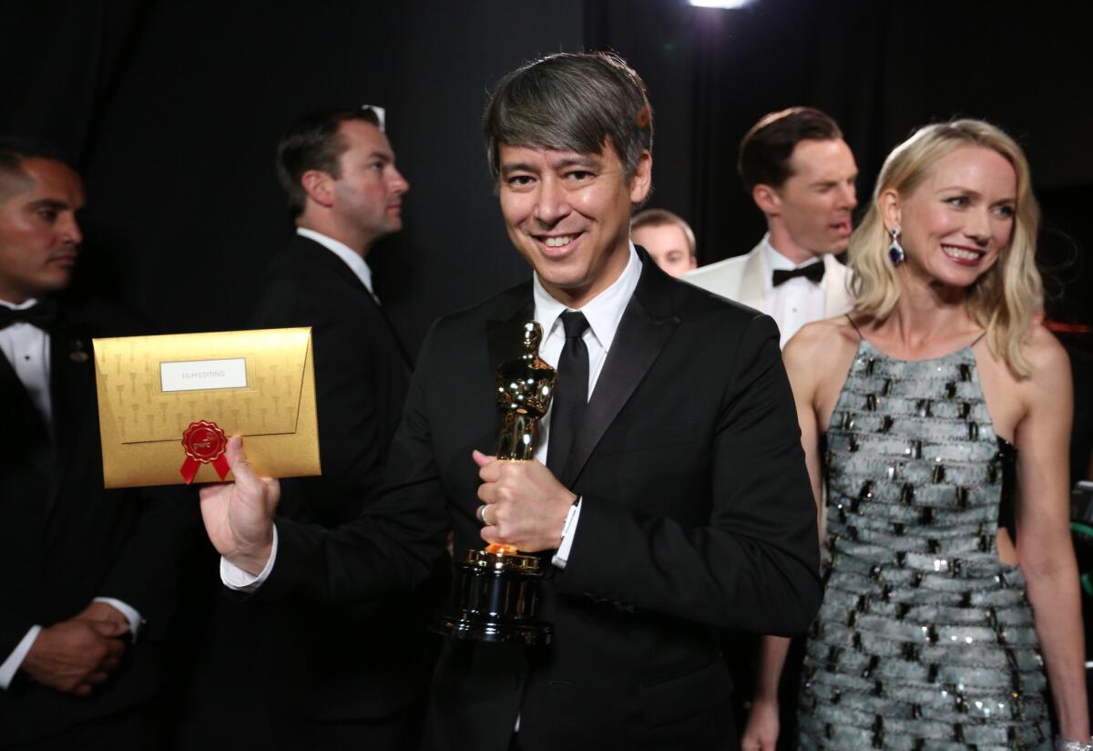 Tom Cross, who won for film editing for "Whiplash," walks backstage with actress Naomi Watts at the 87th annual Academy Awards on Feb. 22, 2015.