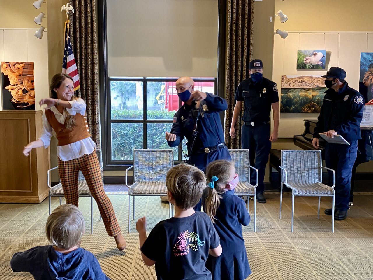 Youth services librarian Katia Graham and San Diego fire Capt. Richard Vigil lead a song at the La Jolla/Riford Library.