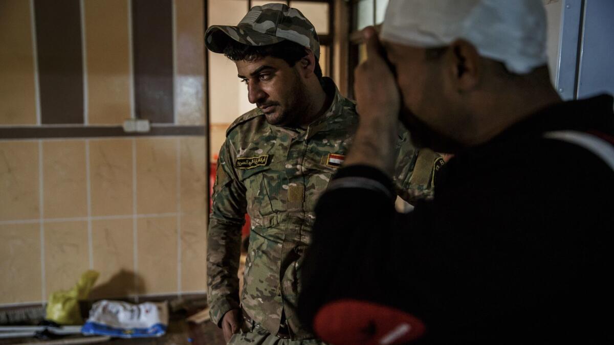 Wissam Daoud, left, talks to Maj. Hussar Kazim, who was injured in a recent mission to clear explosive devices on the front lines ahead of the heavy fighting against Islamic State in west Mosul.