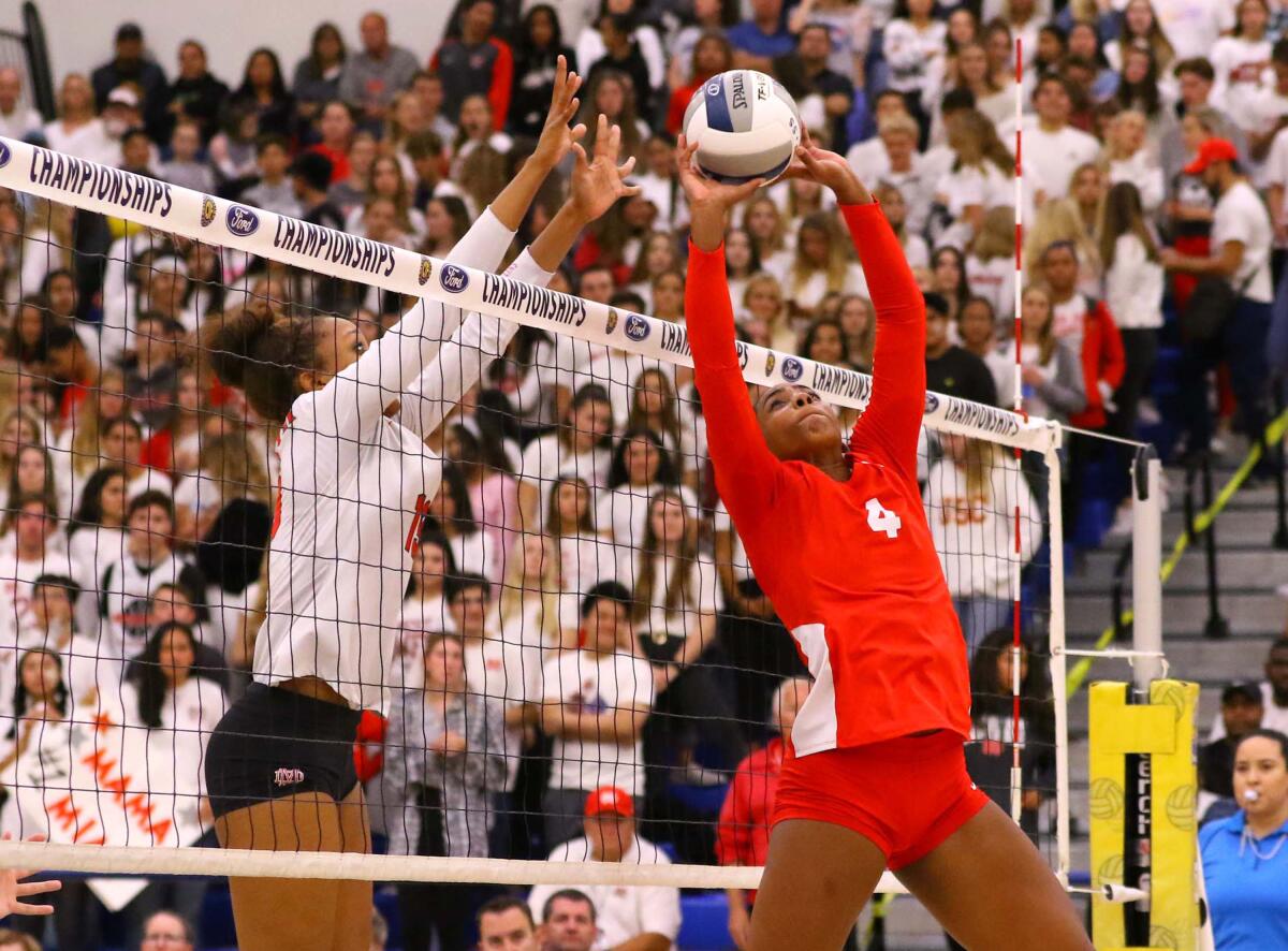 Redondo's Kami Miner (4) looks to set the volleyball while Mater Dei's Zaria Henderson (13) is ready for a block at the net.