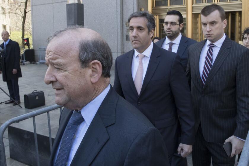 Michael Avenatti, Stormy Daniels' attorney, left, watches as Michael Cohen, center, President Donald Trump's personal attorney, leaves federal court in New York, Thursday, April 26, 2018. President Donald Trump said that Cohen, his personal attorney, represented him "with this crazy Stormy Daniels deal," after previously denying any knowledge of a payment Cohen made to the porn actress who alleges an affair with Trump. (AP Photo/Mary Altaffer)