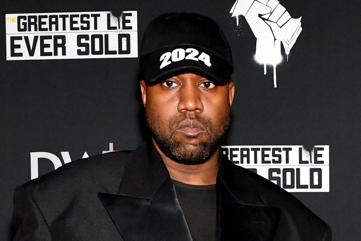 A man wears a hat that says "2024" at a movie premiere