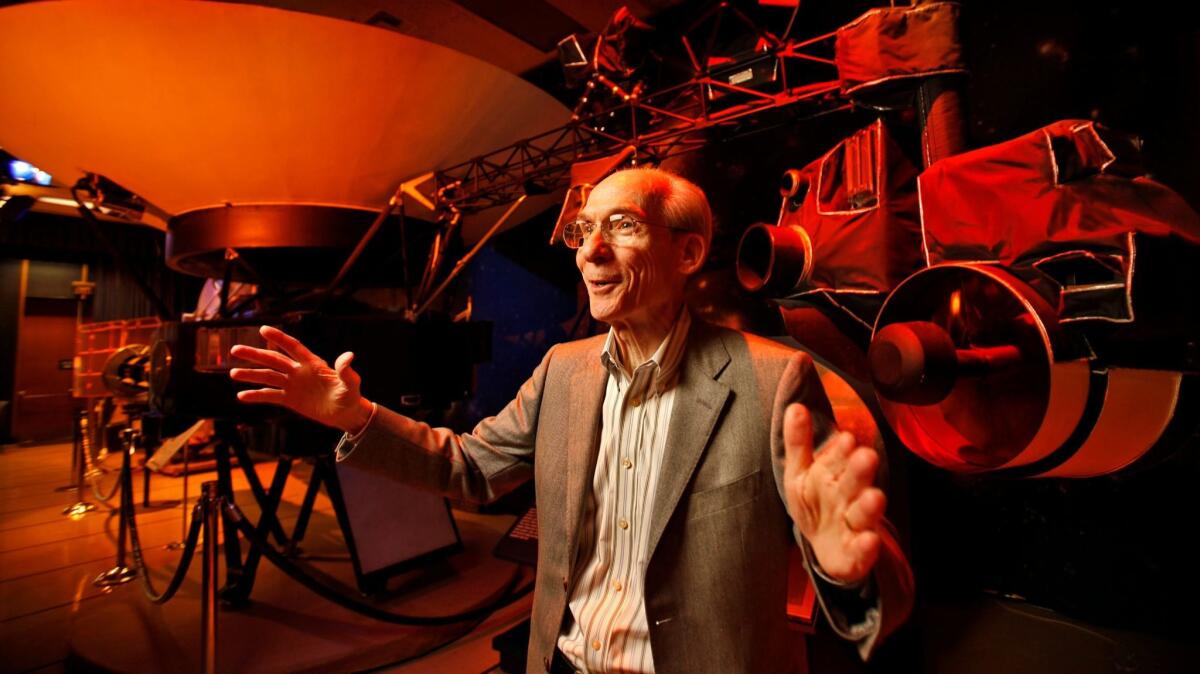 Ed Stone gestures in front of a reddish background