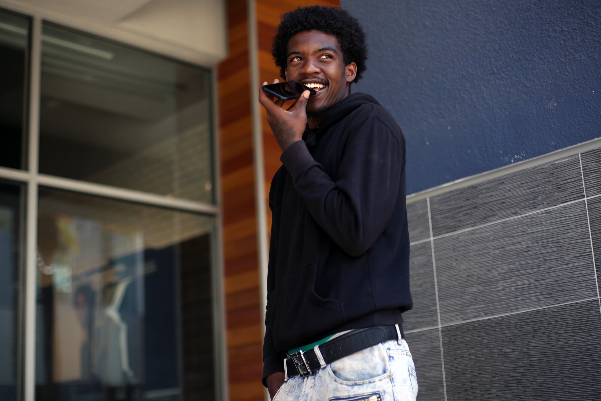 Ja'quest Jones, 19, holds a phone to his face to talk to Dave Stein, a mentor and volunteer with CASA