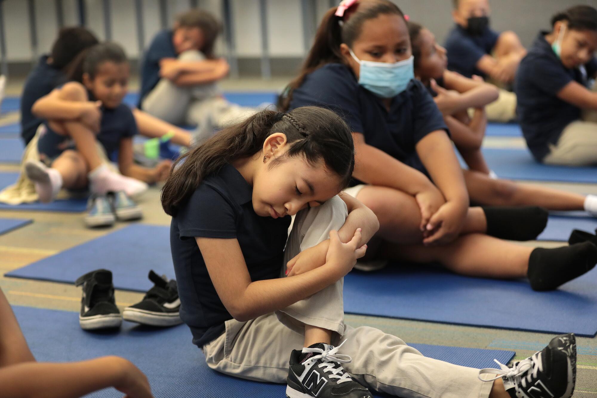 Second grade student Giselle Calderon stretches to instructions from Yoga instructors.