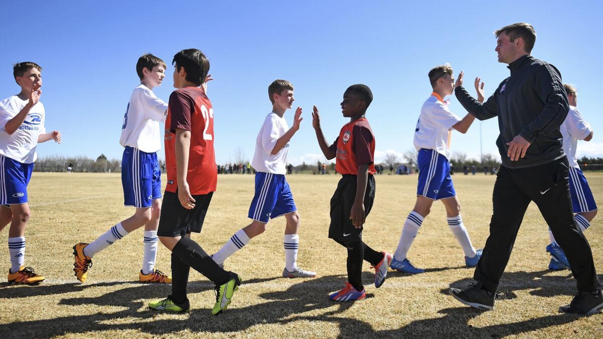 Mtabi Makeci Ebuela, 12, center, and his team shakes hands with opponents after a soccer game in Great Falls, Mont. Mtabi arrived in the U.S. last September with his parents and four siblings after living in a refugee camp in Tanzania.