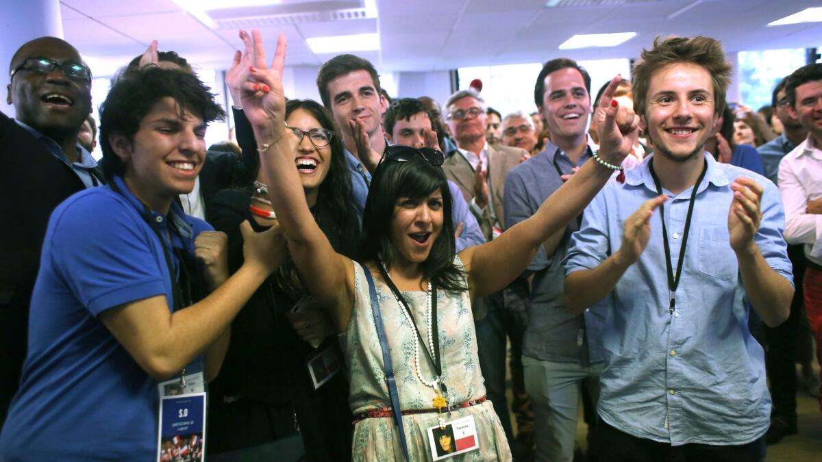 French President Emmanuel Macron's supporters react after the announcement of the first partial election results and polling agency projections in Paris on June 11, 2017.