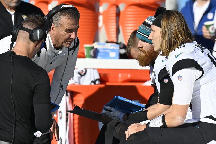 Jacksonville Jaguars head coach Urban Meyer speaks with Jacksonville Jaguars quarterback Trevor Lawrence (16) in the bench area during the first half of an NFL football game against the Tennessee Titans, Sunday, Dec. 12, 2021, in Nashville, Tenn. (AP Photo/Mark Zaleski)
