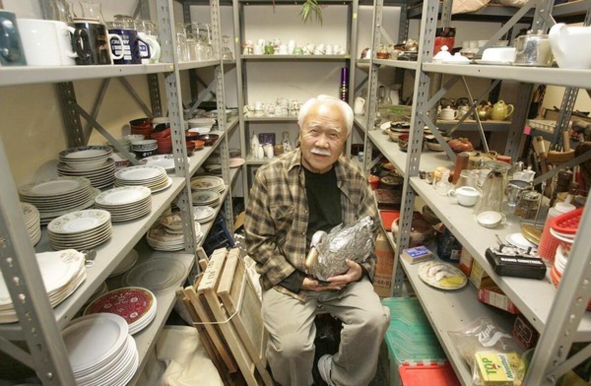 Prop manager Ken Takemoto, holding a remote-control duck he created for a staging of "Pippin," is surrounded by odds and ends from East West Players productions. He has worked with the group since 1989.