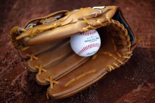 A Wilson baseball glove lies with a baseball in it on the field at PNC Park before a baseball game.