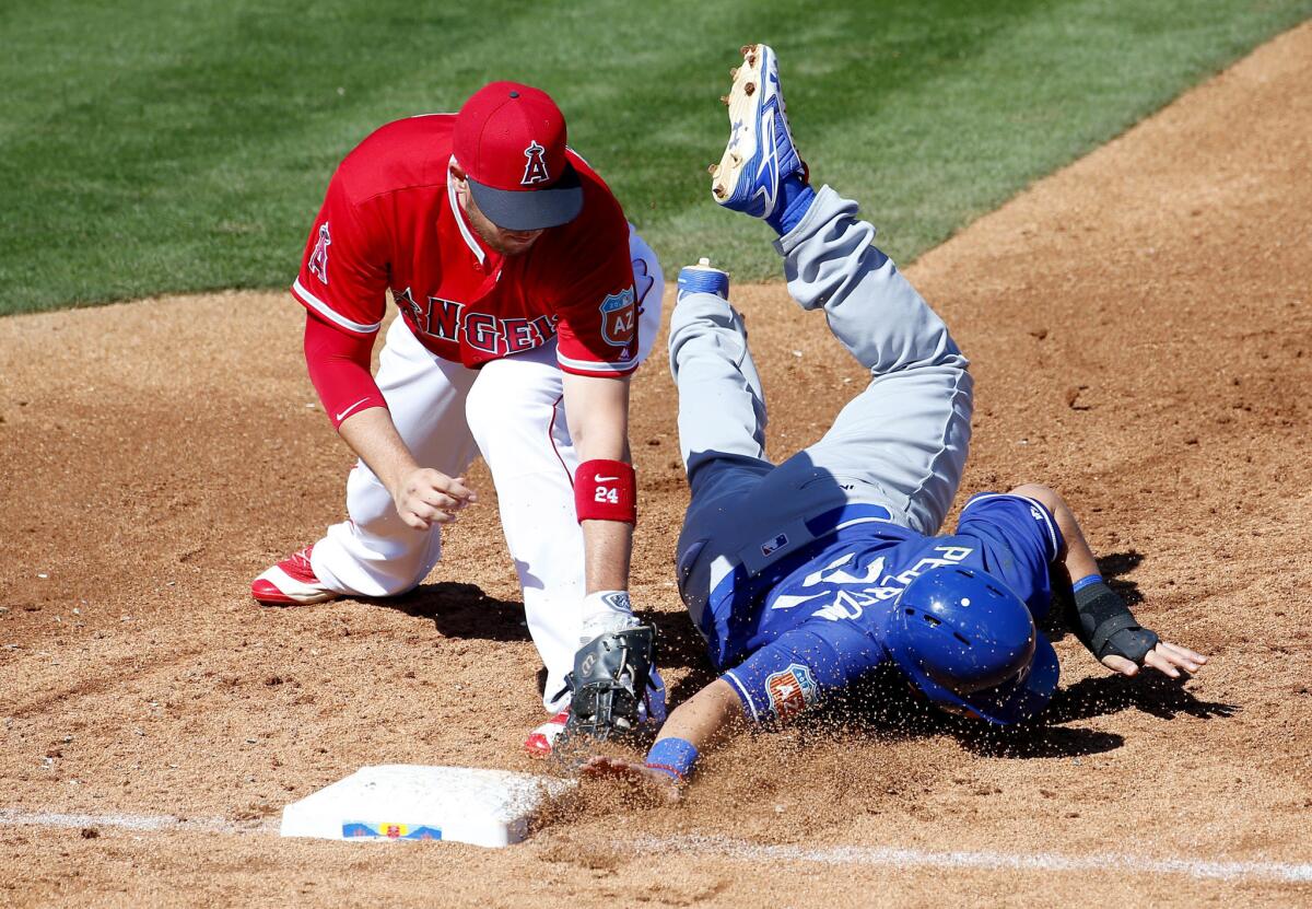 Dodgers outfielder Joc Pederson dives back safely on a pick-off attempt as Angels first baseman C.J. Cron applies the tag during the second inning.