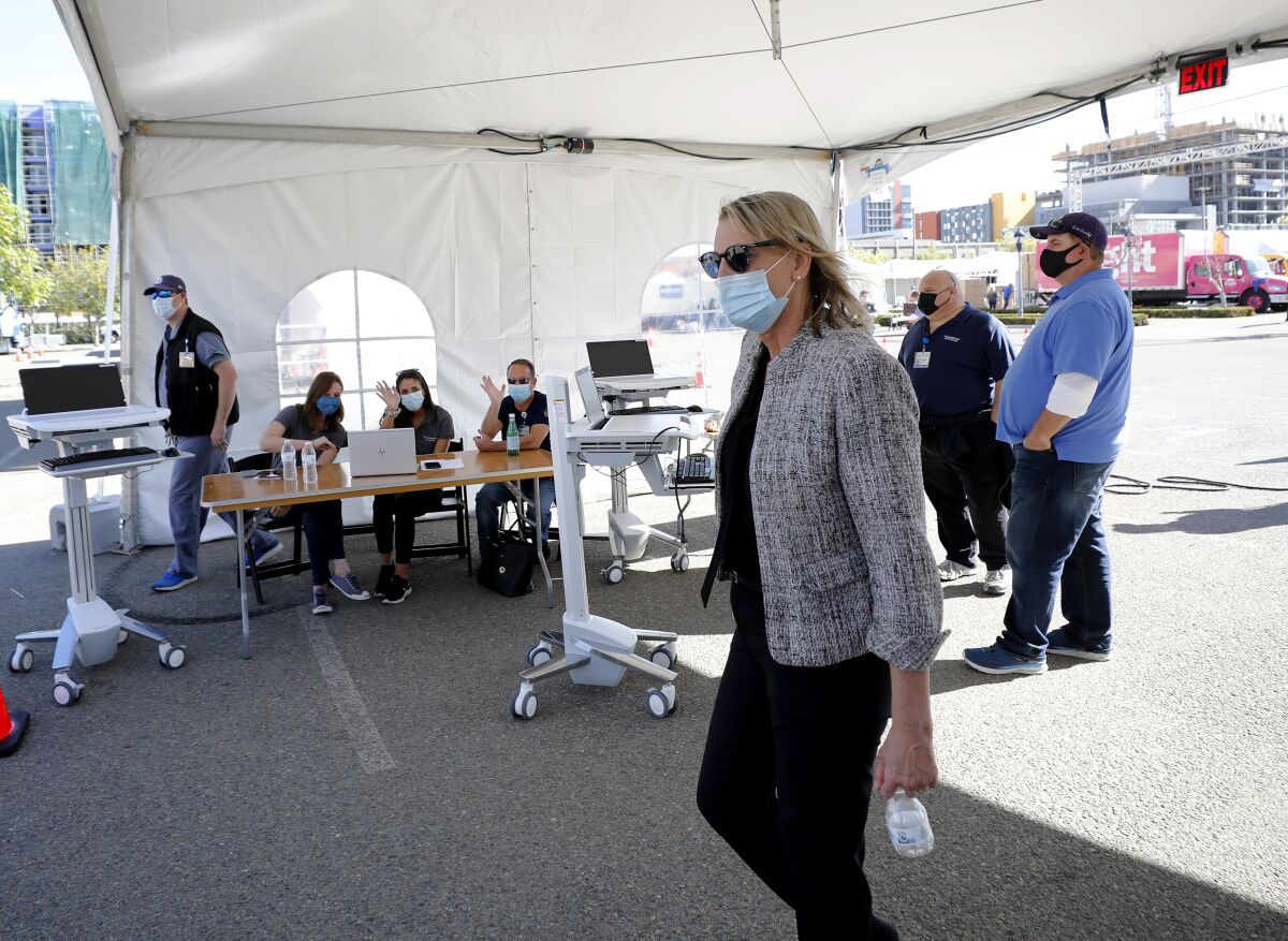 Patty Maysent, CEO of UC San Diego Health, walks through a coronavirus "vaccination super station" near Petco Park.