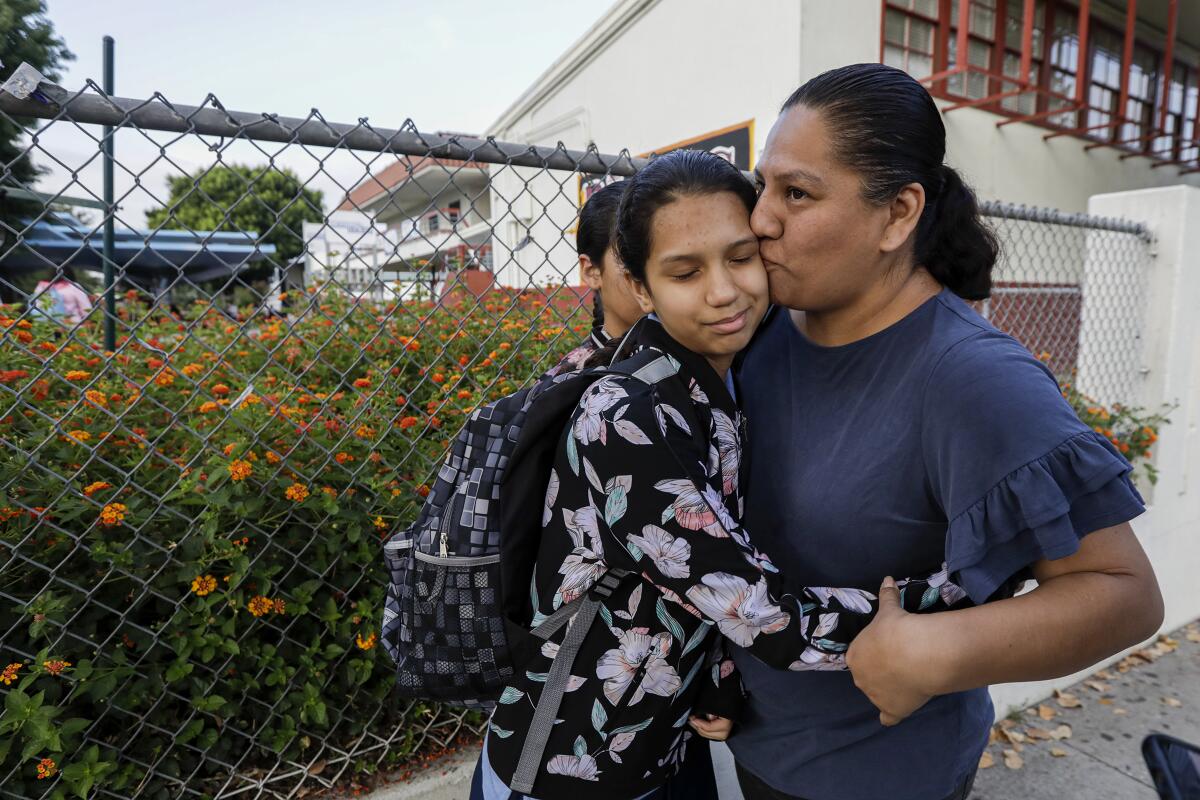 Nereyda Bautista drops her daughter, April Bauitista, off at Hollenbeck Middle School in Boyle Heights. A student was shot in the jaw on August, 27 at the school, possibly struck by a bullet fired from off campus.