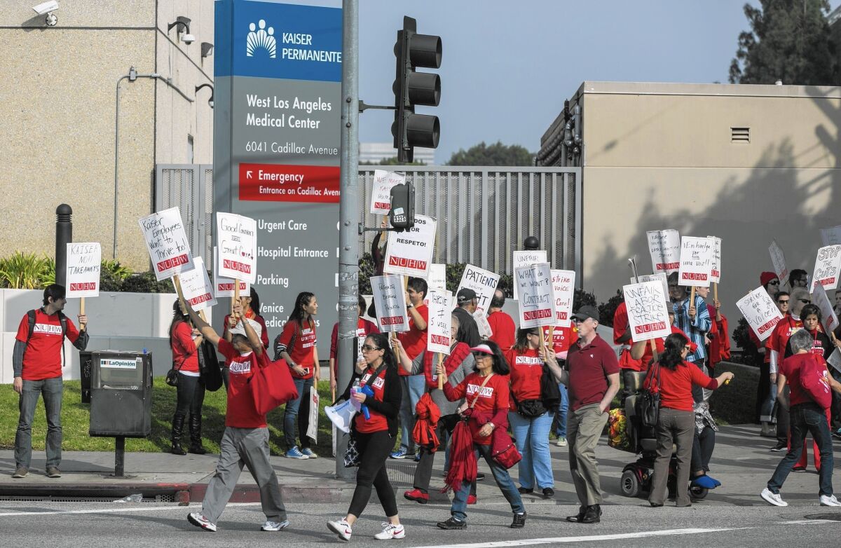 The state Department of Managed Health Care said in a report Tuesday that some Kaiser patients continue to wait weeks to see therapists and psychiatrists. Above, Kaiser mental health workers rally for better policies outside the Kaiser West Los Angeles office in January.
