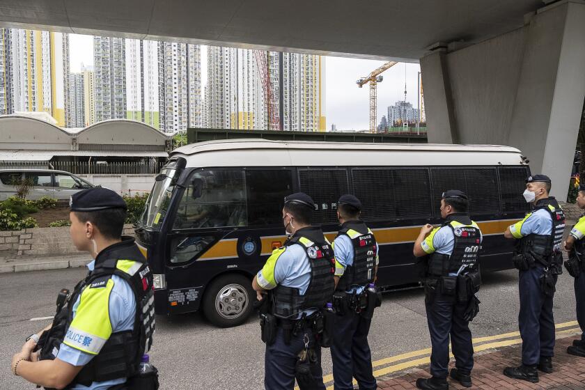 Police officers stand guard as a Correctional Services Department vehicle leaves the West Kowloon Magistrates' Courts in Hong Kong, Thursday, May 30, 2024. Fourteen pro-democracy activists were convicted in Hong Kong’s biggest national security case on Thursday by a court that said their plan to effect change through an unofficial primary election would have undermined the government’s authority and created a constitutional crisis.(AP Photo/Chan Long Hei)