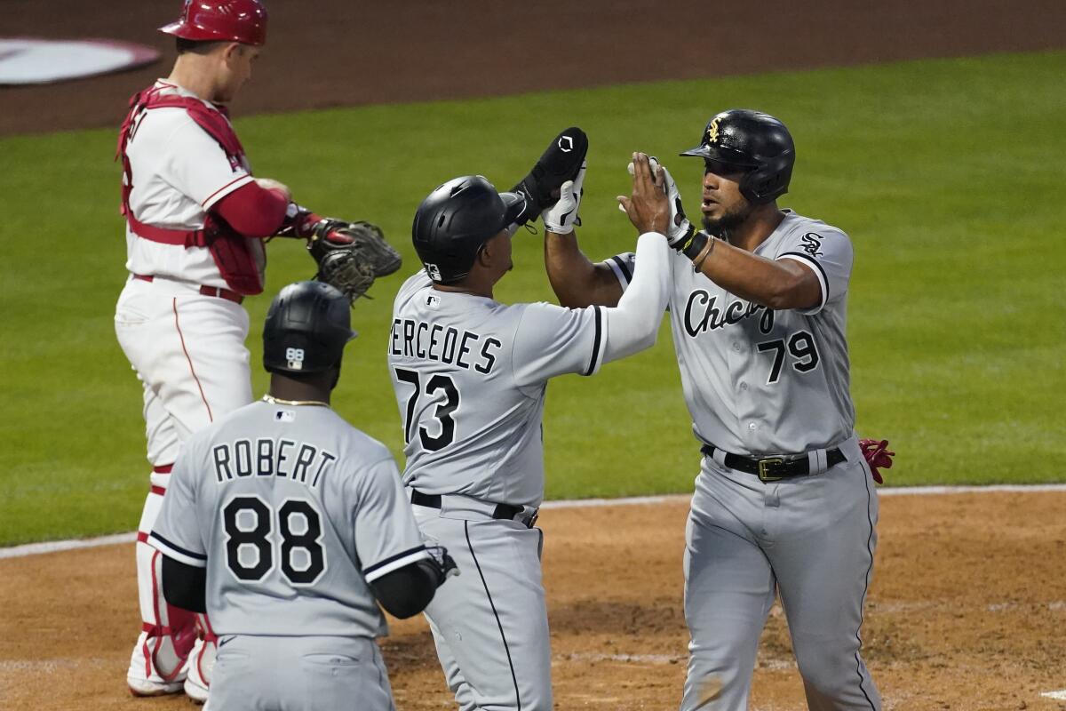 Chicago White Sox first baseman Jose Abreu high-fives Yermin Mercedes after hitting a grand slam.