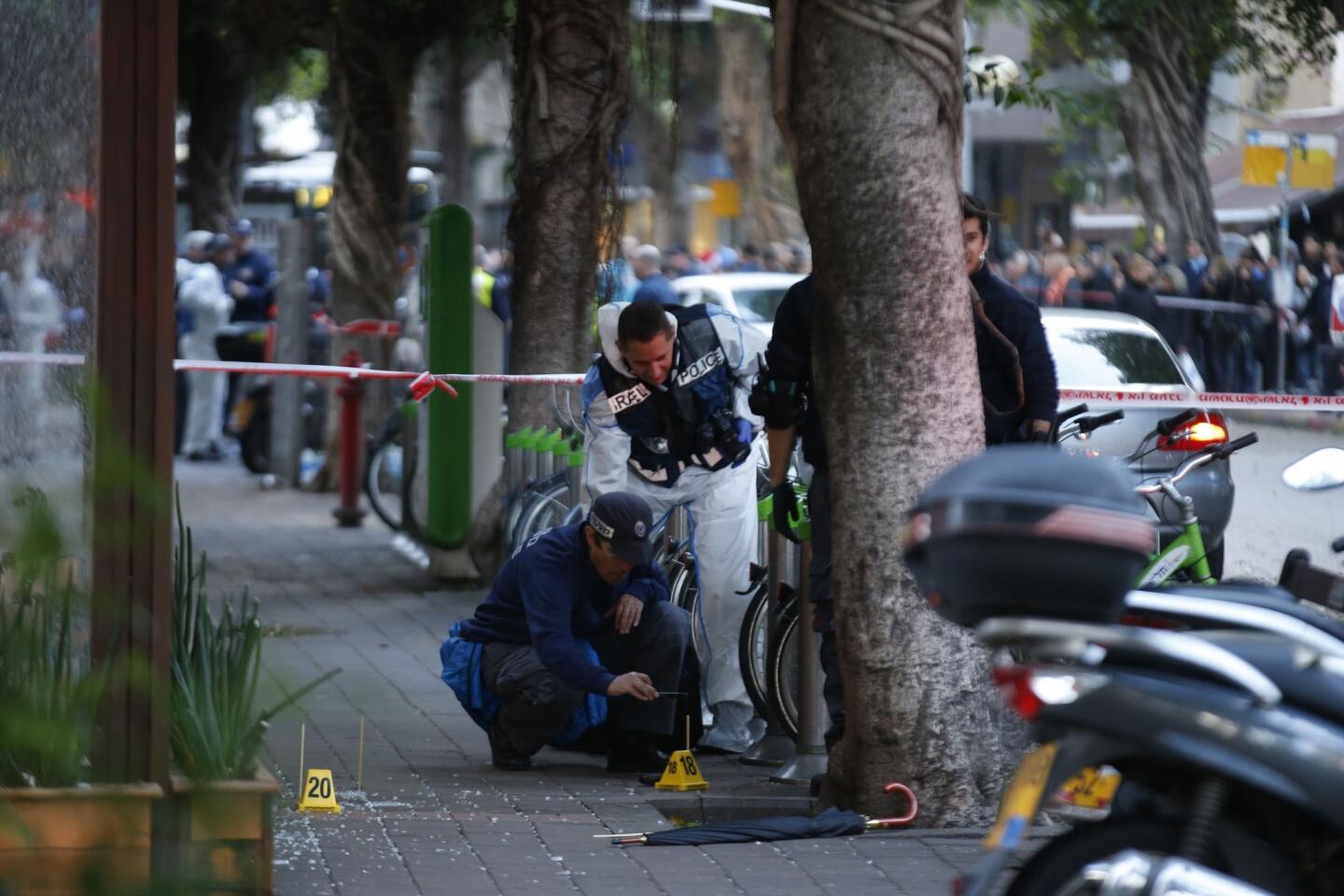 Israeli forensics inspect the site of an attack by an unidentified gunman, who opened fire at a pub in the Israeli city of Tel Aviv killing two people and wounding five others on Jan. 1, 2016, police and medical officials said.