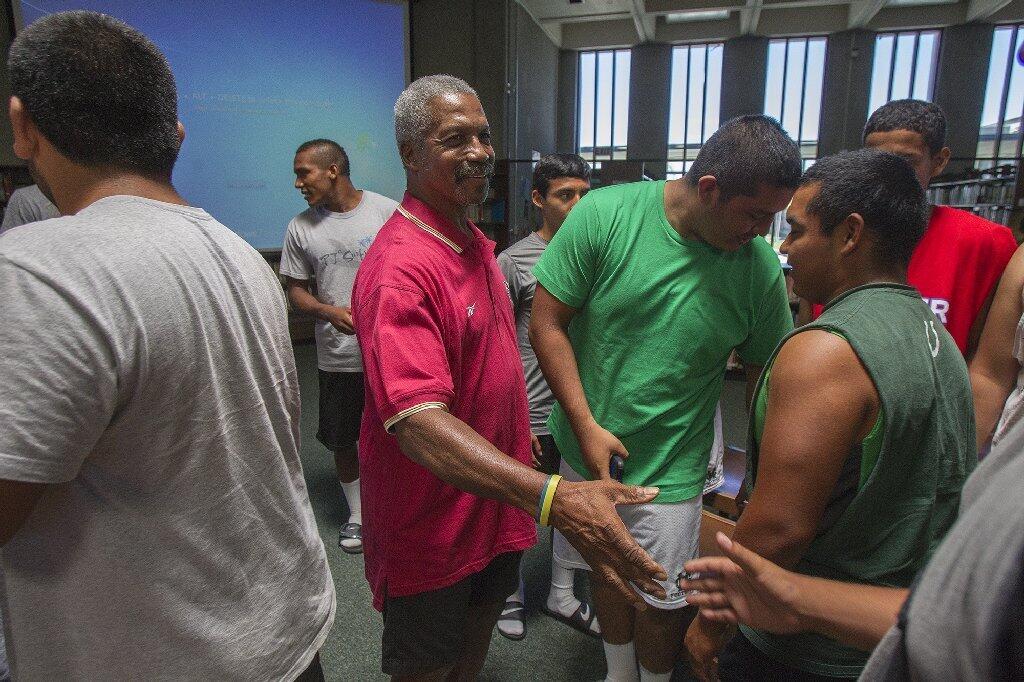 Kermit Alexander, a former NFL defensive back, shakes hands with members of the Costa Mesa High football team on Wednesday.