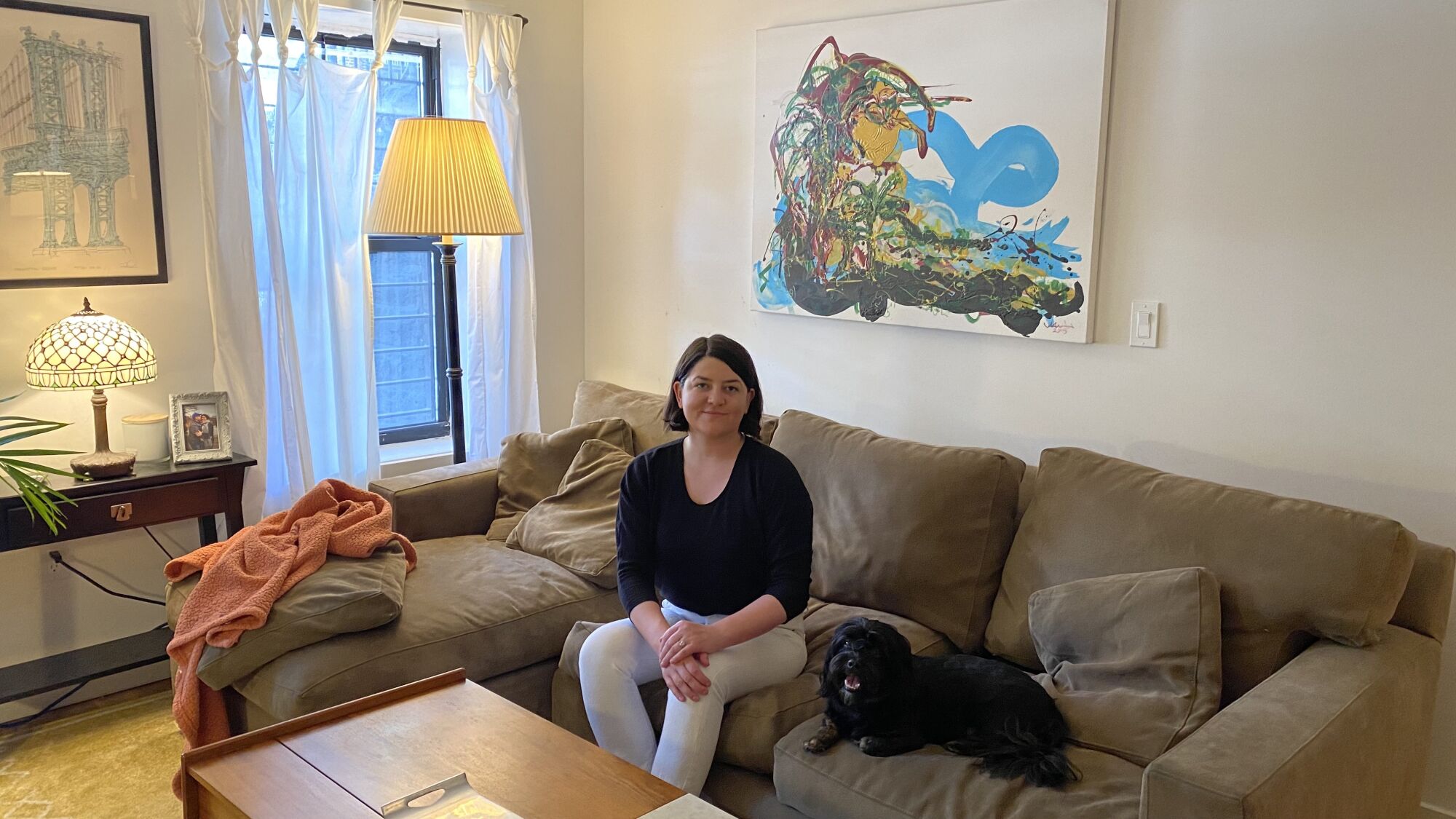 A woman sitting on the sofa with her dog in the apartment