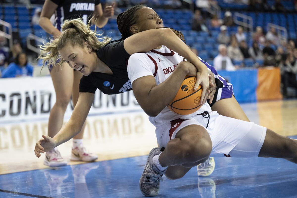Portland forward Lucy Cochrane, left, and Oklahoma forward Liz Scott scramble for the ball during the first half of a first-round college basketball game in the women's NCAA Tournament, Saturday, March 18, 2023, in Los Angeles. (AP Photo/Kyusung Gong)