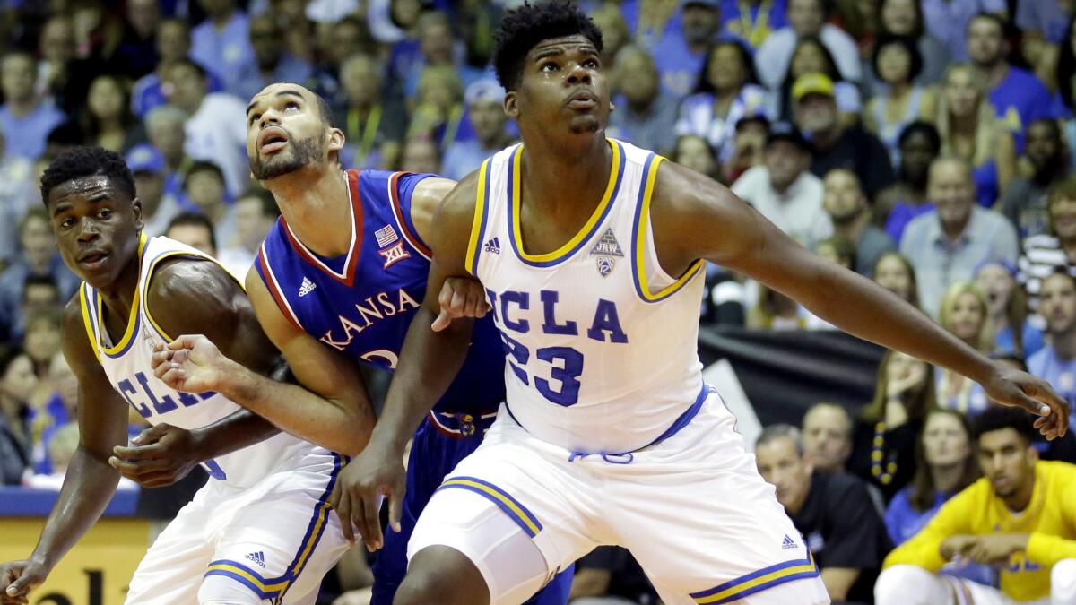 UCLA forward Tony Parker and guard Aaron Holiday battle Kansas forward Perry Ellis for rebounding position during a game Tuesday.