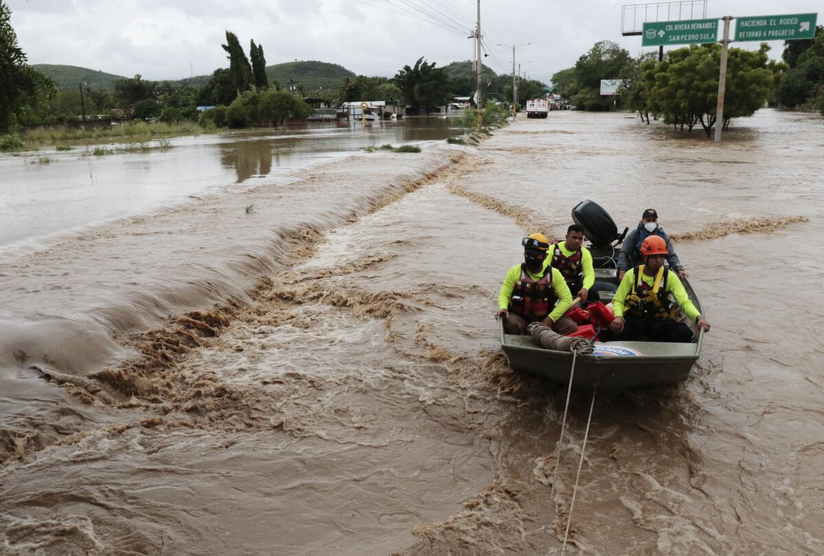 Rescuers navigate a flooded road in a boat after Hurricane Iota passed through La Lima, Honduras.