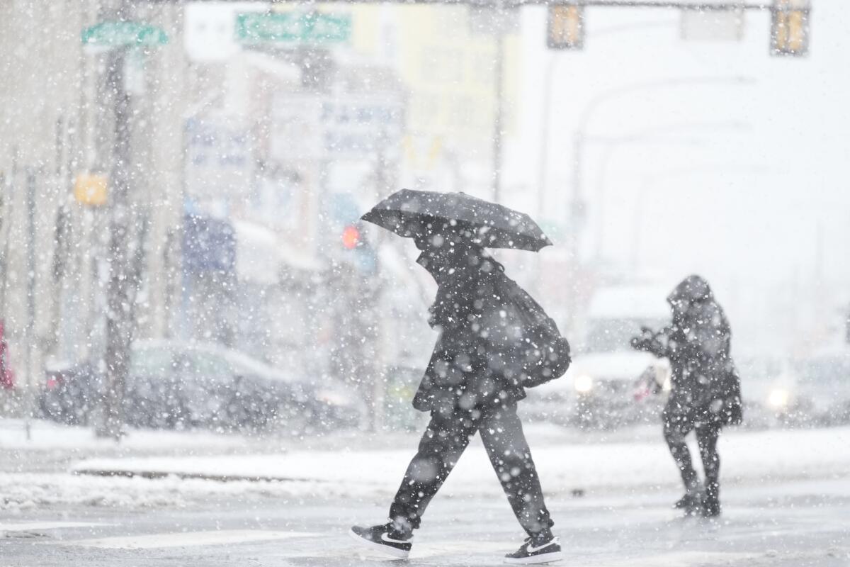 People crossing a street during a winter snow storm in Philadelphia