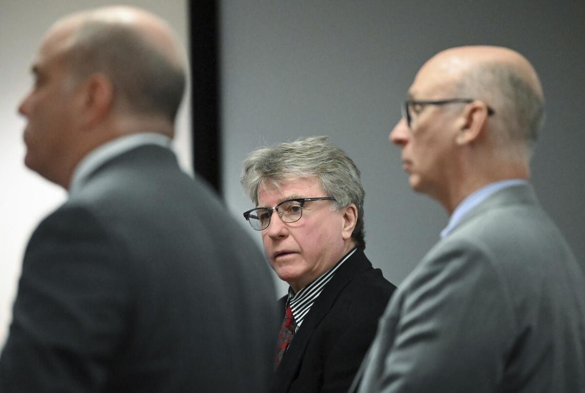 Defendant Kevin Monahan, center, is flanked by his legal defense.