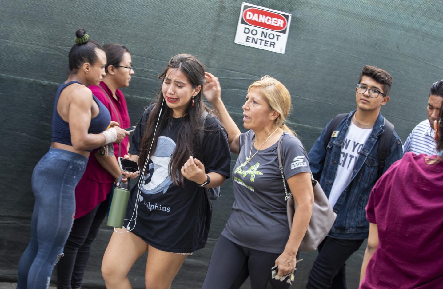A student cries as her mother picks her up from the reunion gate at CHAMPS Charter High School of the Arts after a shooting near the Van Nuys campus.