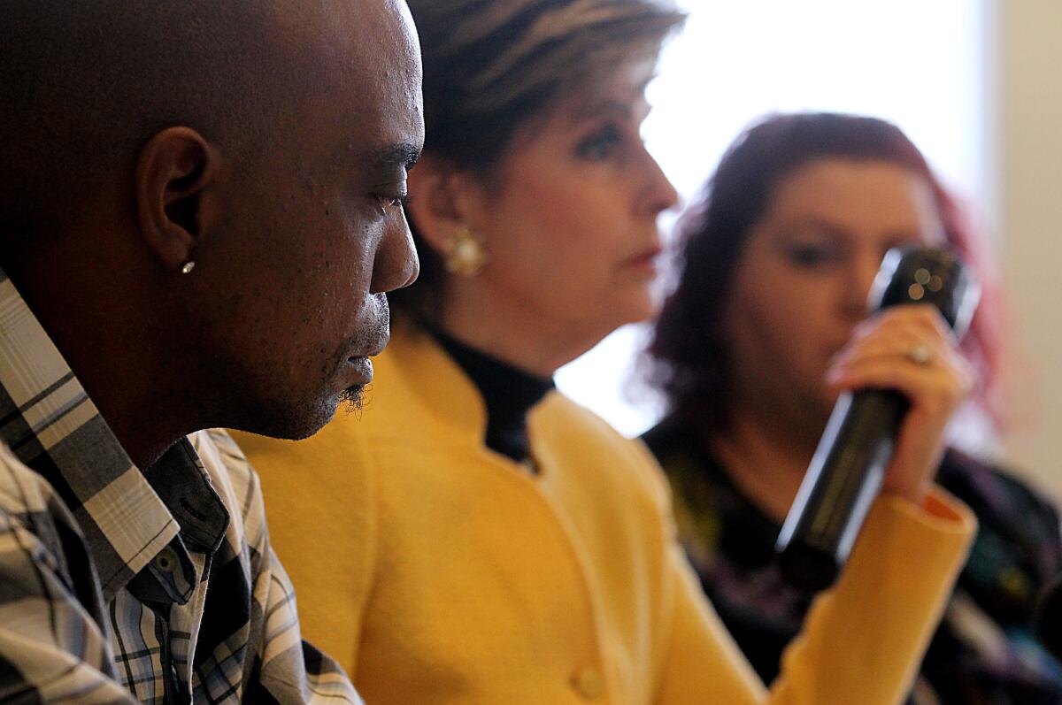 Bret Phillips looks on as attorney Gloria Allred, center, displays the type of flashlight that a Los Angeles County sheriff's deputy allegedly used to beat Phillips while he was detained at an L.A. County Jail in 2009. Two of the deputies who beat Phillips face federal charges of violating his civil rights.