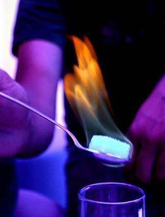 An absinthe-soaked sugar cube is set afire over a drink at Latte Più, a Roman milk bar patterned after "Clockwork Orange's" Korova. The burning granules fall into the glass, sweetening the bitter alcohol, which tastes of black licorice.