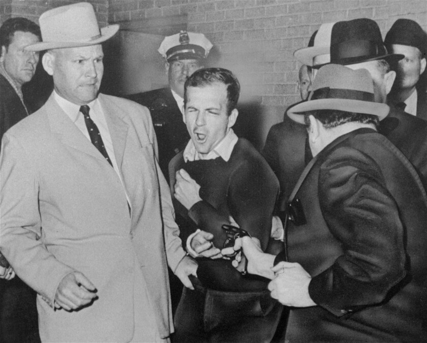 Lee Harvey Oswald, accused assassin of President John F. Kennedy, is shot by nightclub owner Jack Ruby in the basement of Dallas police headquarters on Nov. 24, 1963. Police Det. Jim Leavelle, left, was handcuffed to Oswald.