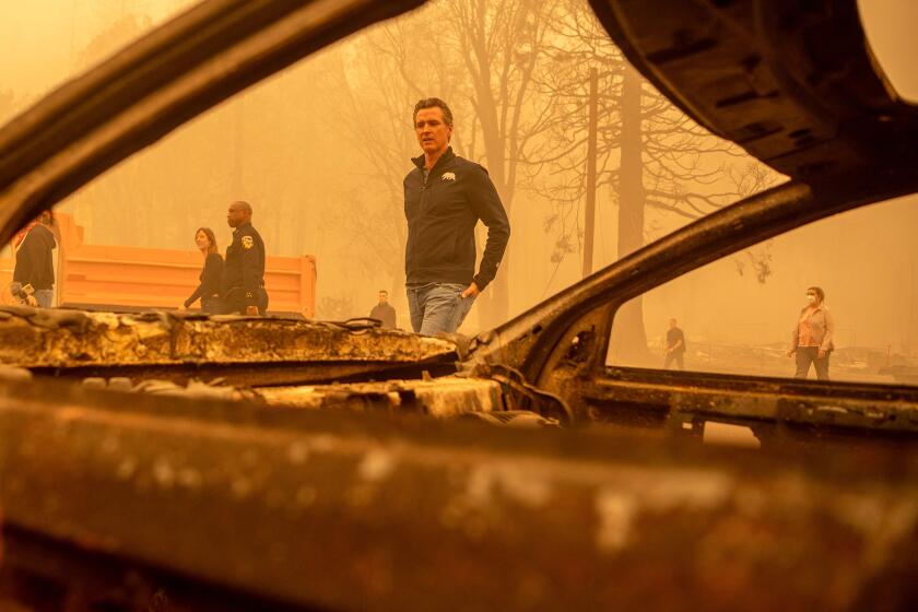 California Governor Gavin Newsom (C) walks by a burned vehicle in downtown Greenville, California on August 7, 2021. - The Dixie fire has now burned more than 430,000 acres and is the largest single fire in California state history. (Photo by JOSH EDELSON / AFP) (Photo by JOSH EDELSON/AFP via Getty Images)